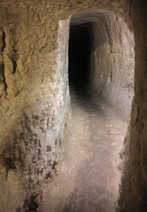 Un étroit couloir menant vers l’obscurité dans les catacombes du musée Wignacourt.